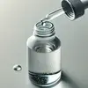 Minimalistische Nahaufnahme einer Tropfflasche, die kolloidale Mineralien in ein Glas Wasser gibt.